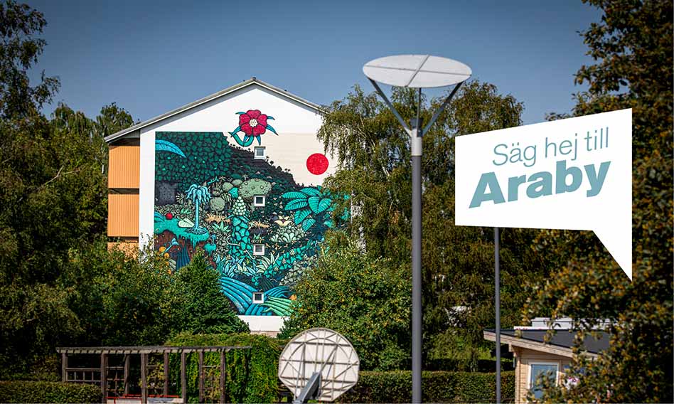 Foto på en fastighet på Araby med en muralmålning på. Text i bild: Säg hej till Araby